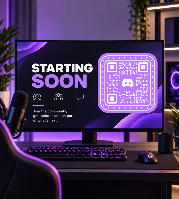 A monitor showing a purple “Starting soon” stream screen with a rounded QR code, on a streaming desk with a microphone, keyboard and mouse