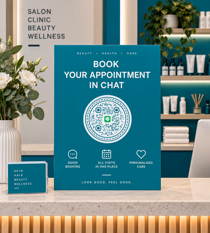 A teal “Book your appointment in chat” sign with a white circular QR code, standing on a salon reception counter