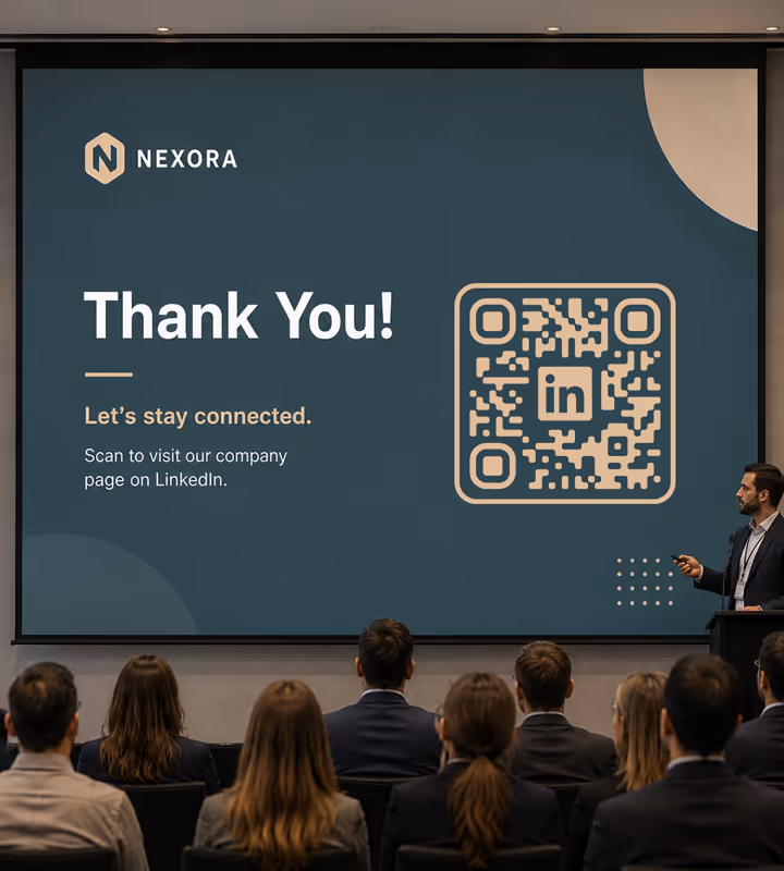 A conference screen showing a “Thank you - let's stay connected” closing slide with a large rounded QR code, an audience seated in front of it