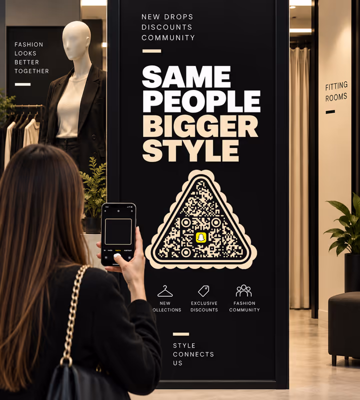 A black in-store panel reading “Same people, bigger style” with a cream triangular QR code, a shopper scanning it beside the fitting rooms