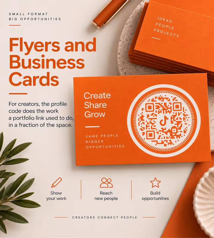 Orange business cards reading “Create, share, grow” with a white circular QR code, fanned out on a cream surface beside a leaf
