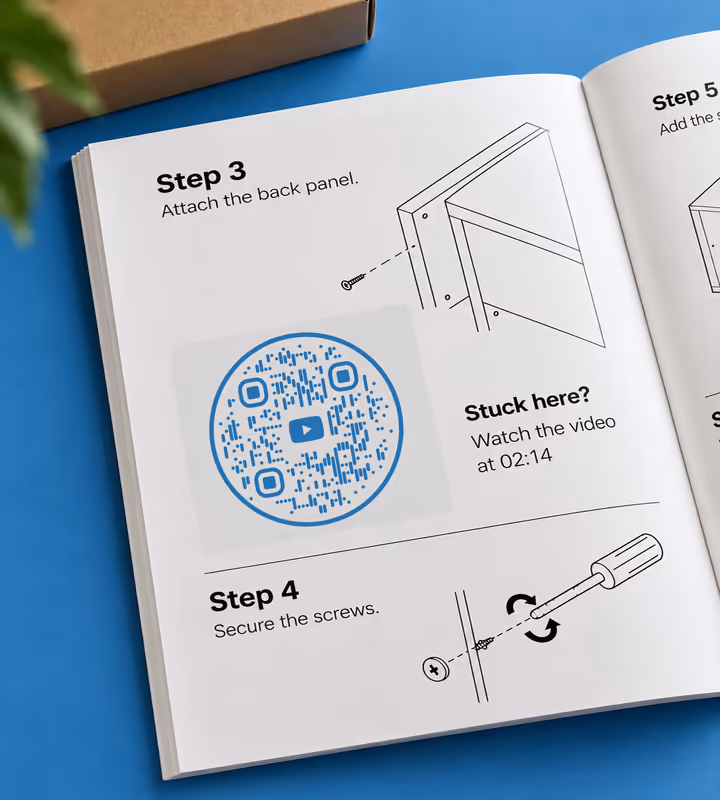 An open instruction booklet at “Step 3: attach the back panel” with a blue circular QR code and “Stuck here? Watch the video at 02:14”