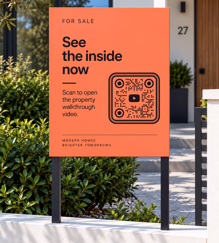 An orange “For sale - see the inside now” board with a black rounded QR code and “Scan to open the property walkthrough video”, outside a house