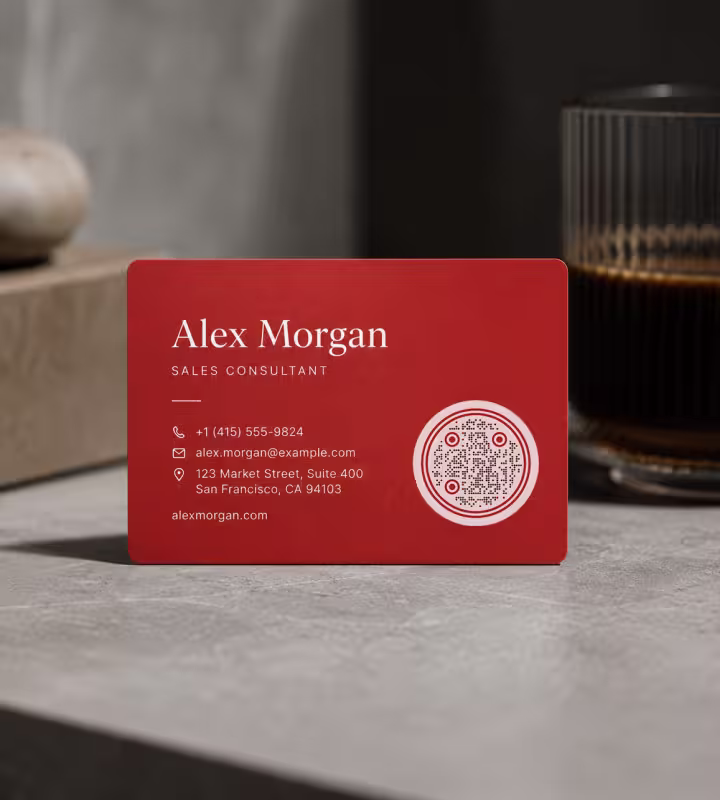นามบัตรสีแดงของ Alex Morgan วางบนเคาน์เตอร์หินอ่อน มี QR Code ทรงกลมอยู่ข้างเบอร์โทรศัพท์และข้อมูลติดต่อ