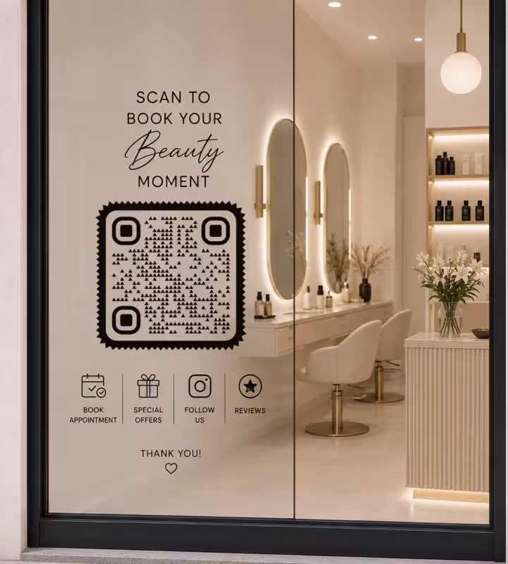 A salon window decal reading “Scan to book your beauty moment” with a large QR code and icons for appointments, offers, social and reviews, with the styling chairs and lit mirrors behind the glass