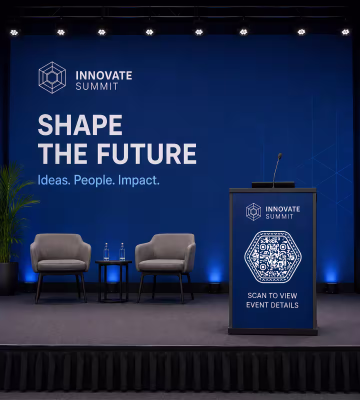 A conference stage with a “Shape the future” backdrop, two armchairs and a lectern carrying a hexagonal QR code marked “Scan to view event details”