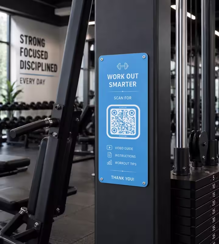 केबल मशीन के ढाँचे पर कसी नीली प्लेट, जिस पर “Work out smarter - scan for video guide, instructions and workout tips” और QR कोड है